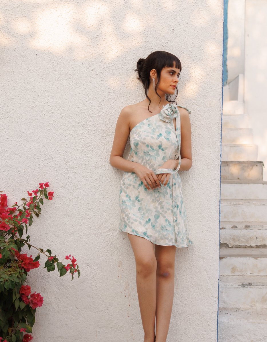 House of Pri fashion editorial — floral dress against a white coastal wall